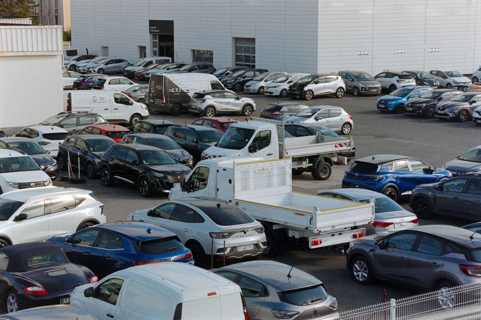 A large outdoor parking lot filled with rows of parked cars