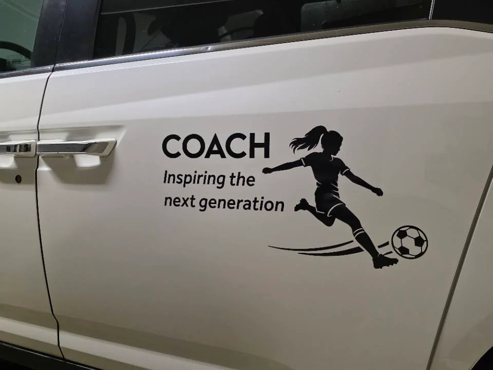 Black Coach Inspiring the next generation soccer decal installed on a white client vehicle door
