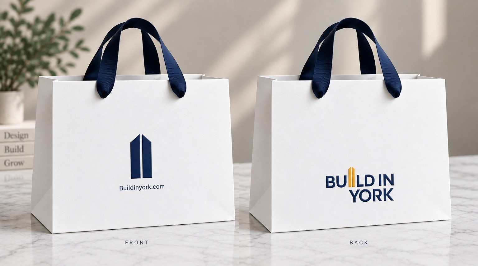 Premium custom white paper bags with navy ribbon handles and printed branding
