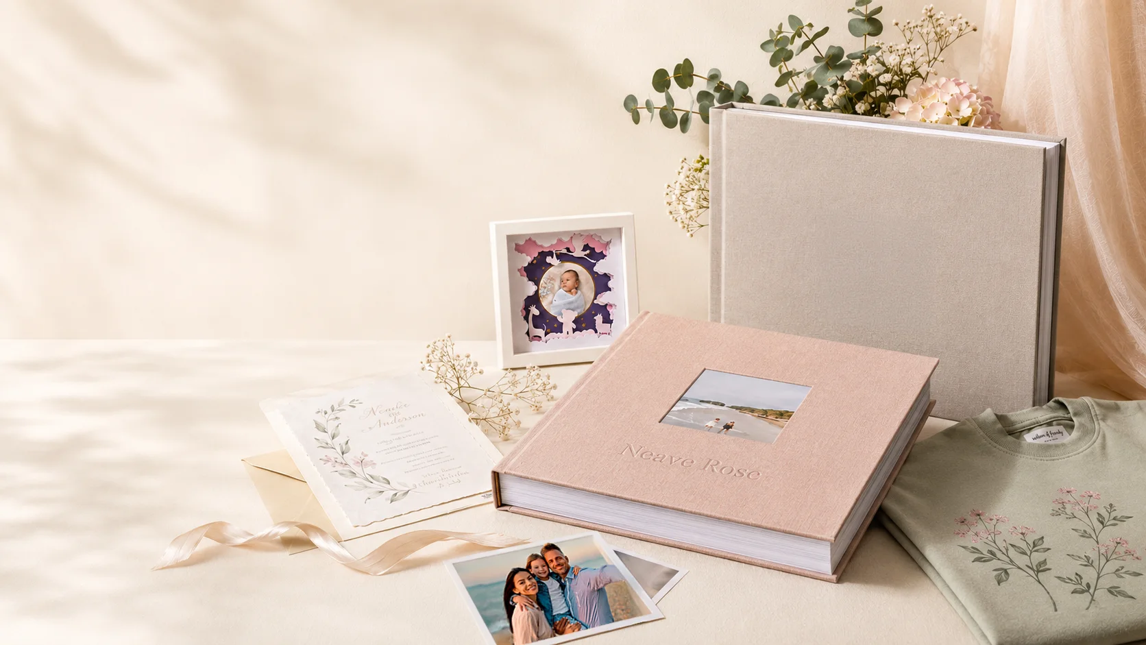 Avenoir hero composition with keepsake album, layered frame, invitation, family photos, and embroidered floral shirt in warm daylight