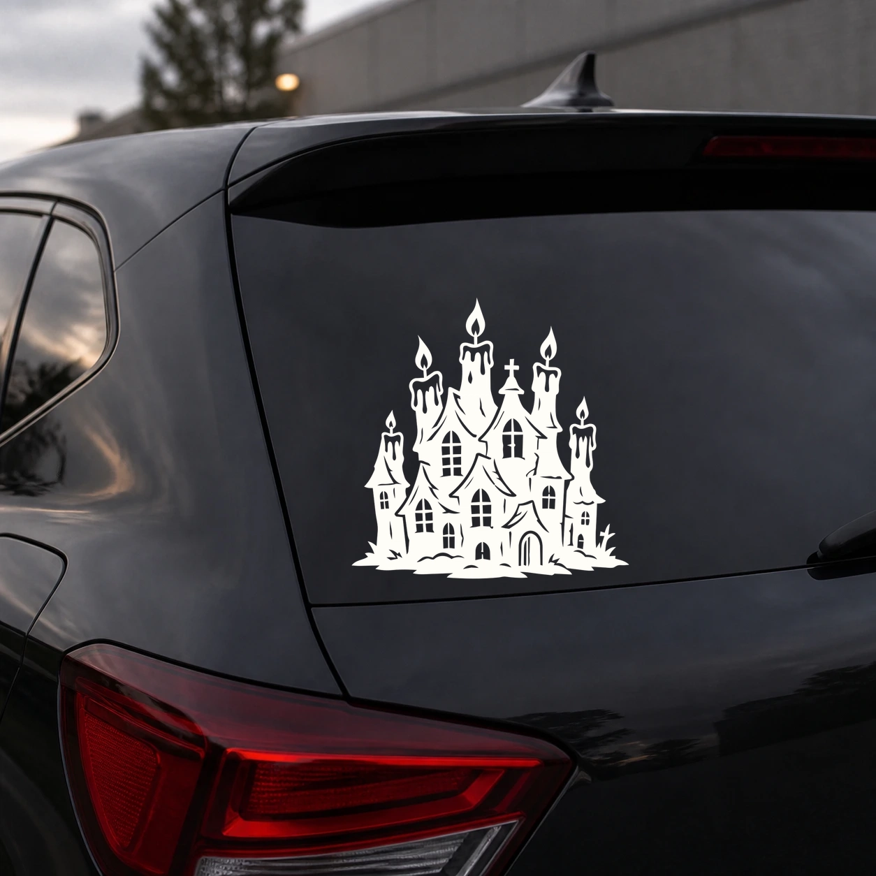 Warm ivory candlelit haunted house decal on a dark vehicle rear window