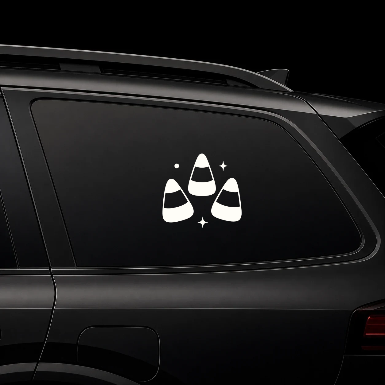 Candy corn trio decal on a dark vehicle window
