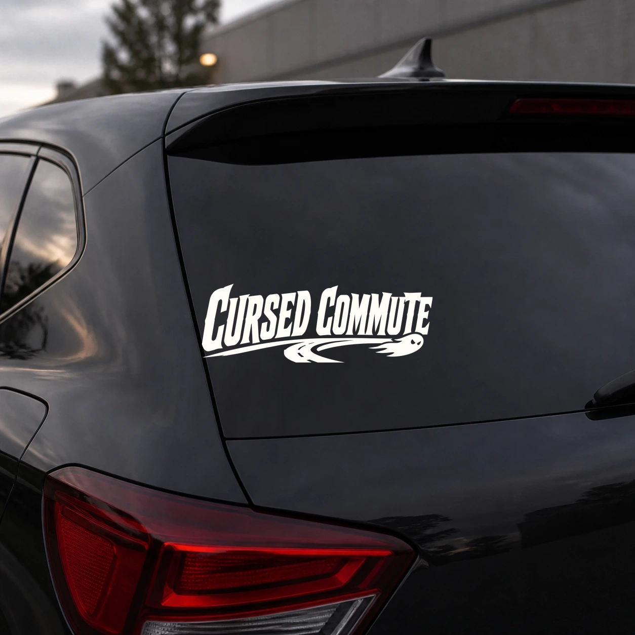 Warm ivory cursed commute decal on a dark vehicle rear panel