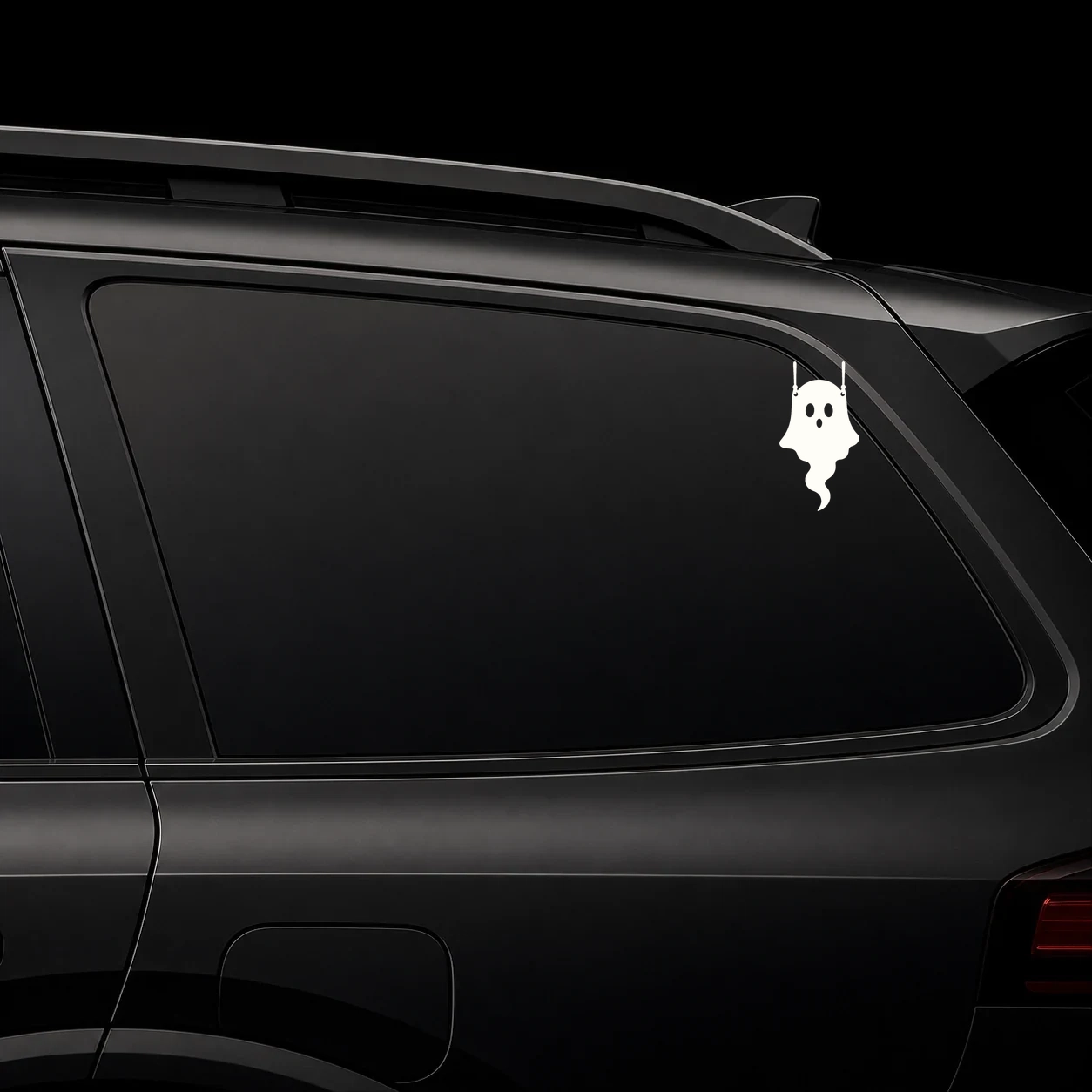Cute hanging ghost decal on a dark vehicle window