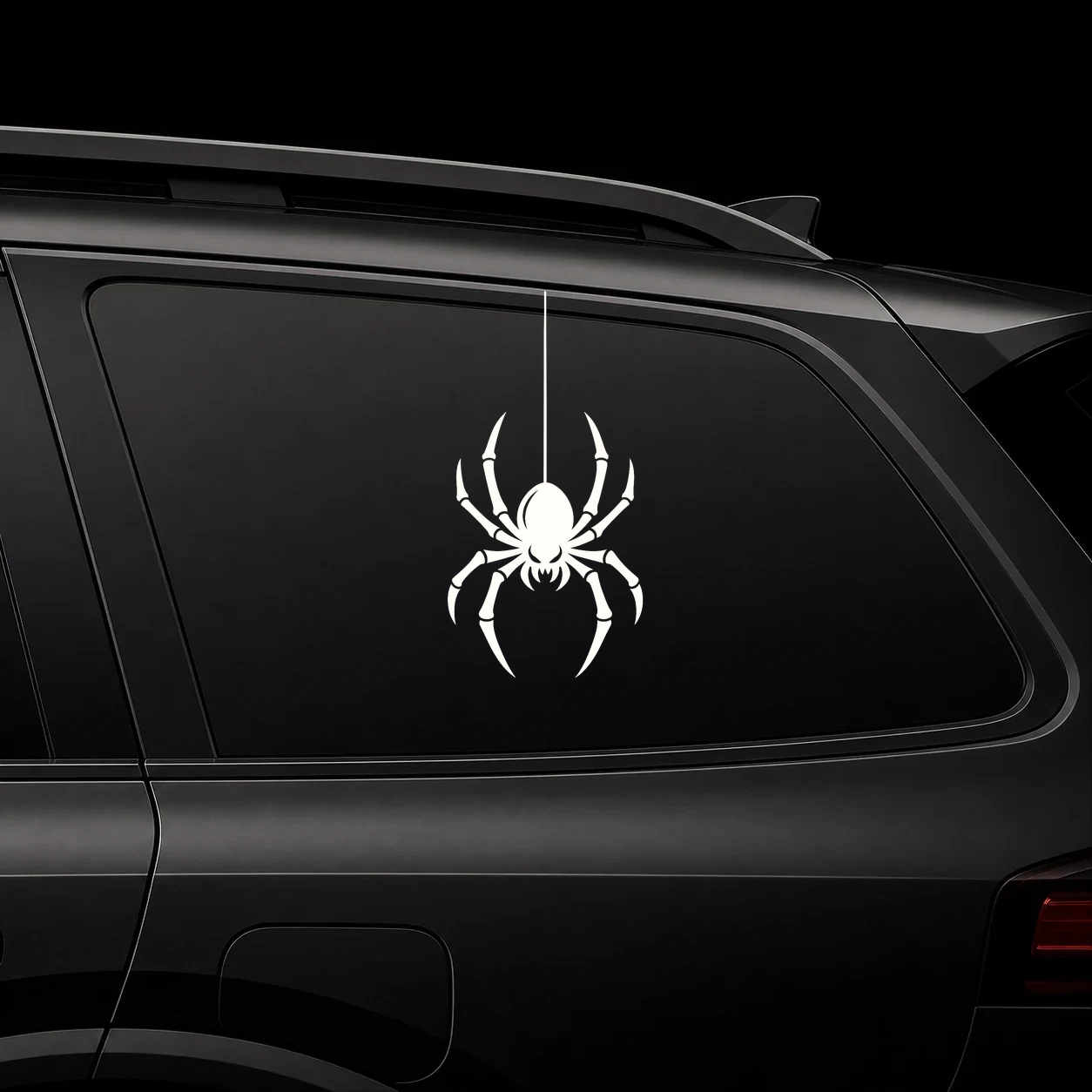 hanging spider decal on a dark vehicle window