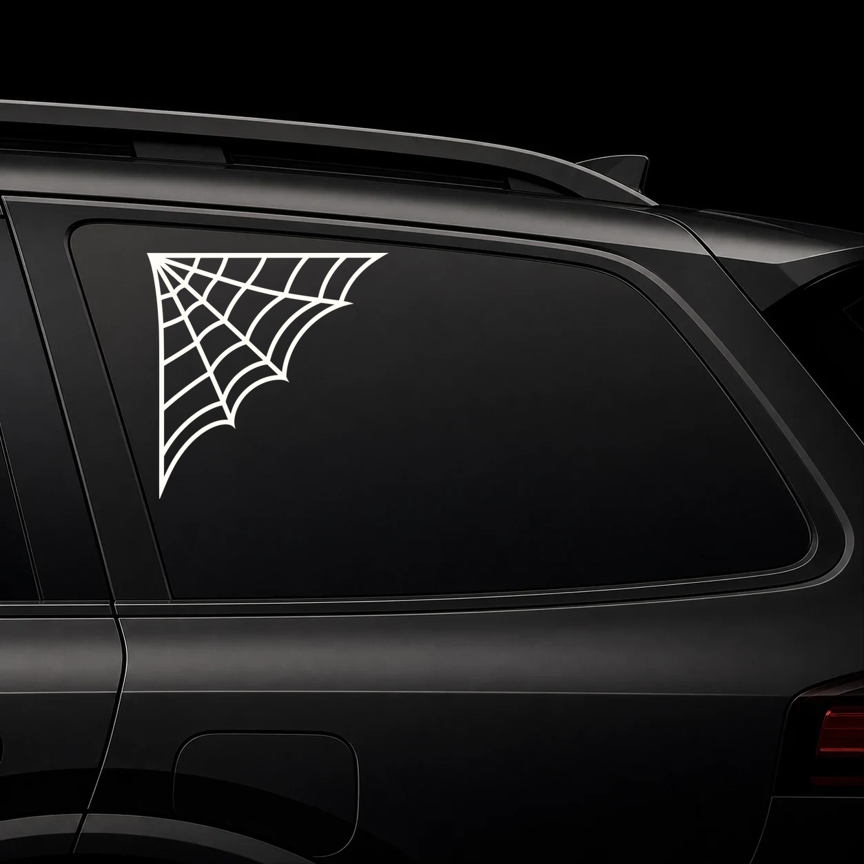 Spider web corner decal on a dark vehicle window
