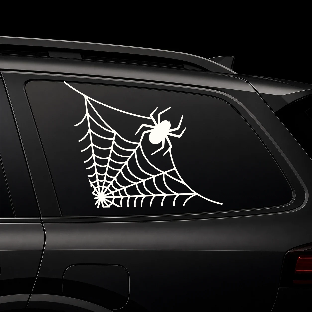 Warm ivory spider web with crawling spider vinyl decal on a dark vehicle window
