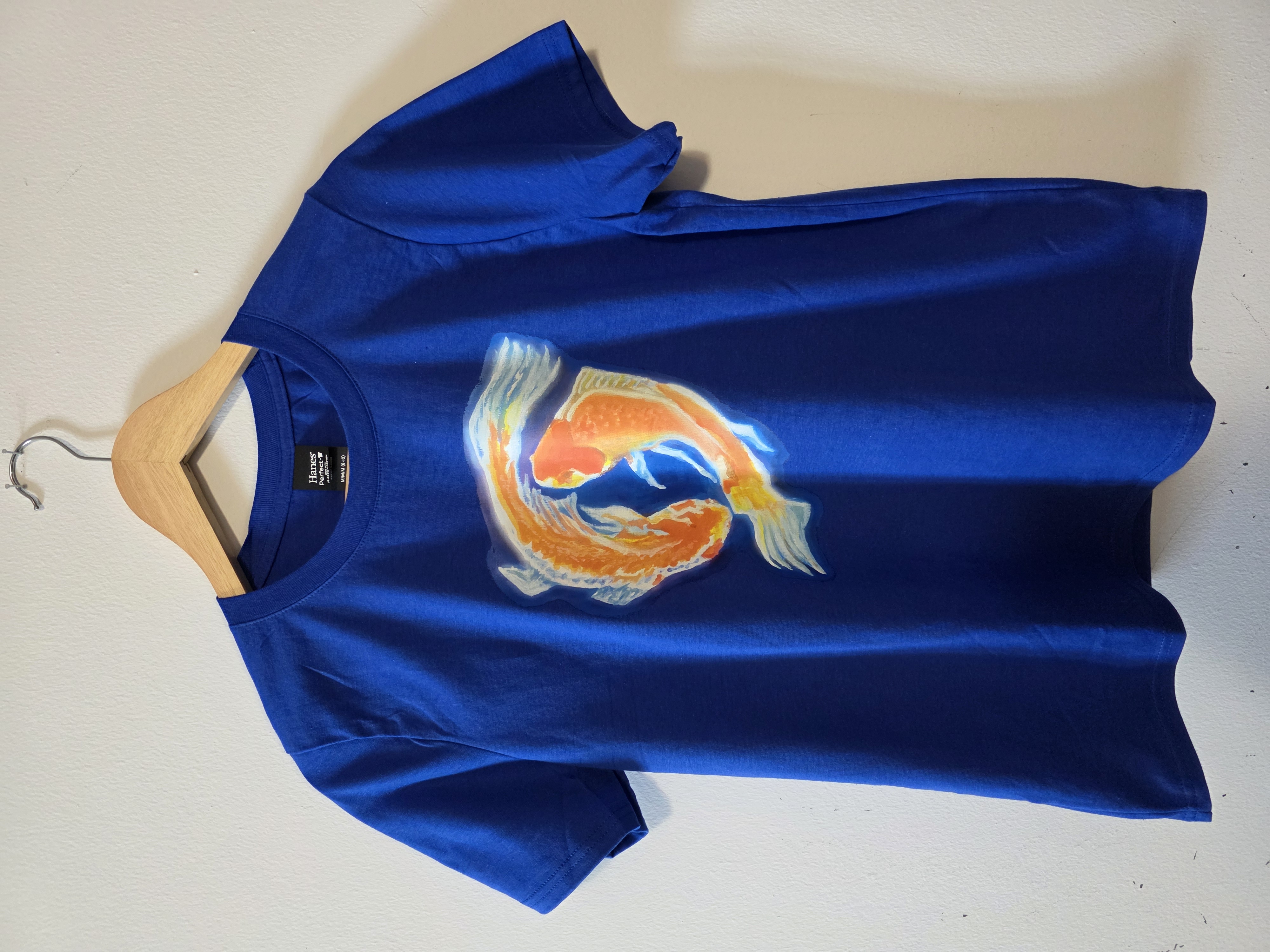 Blue T-shirt printed with the Pisces Dream artwork.