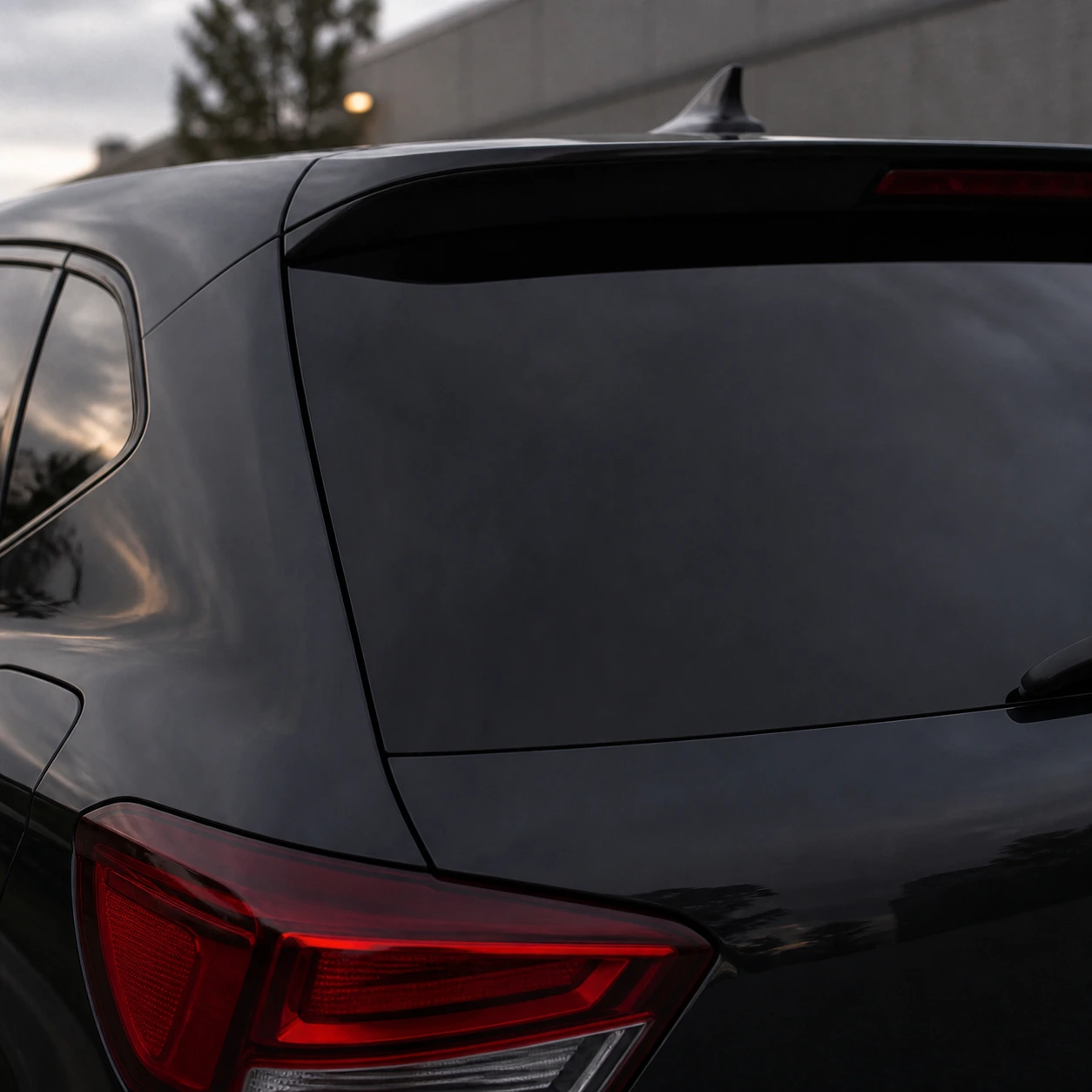 Warm ivory cursed commute decal on a dark vehicle rear panel